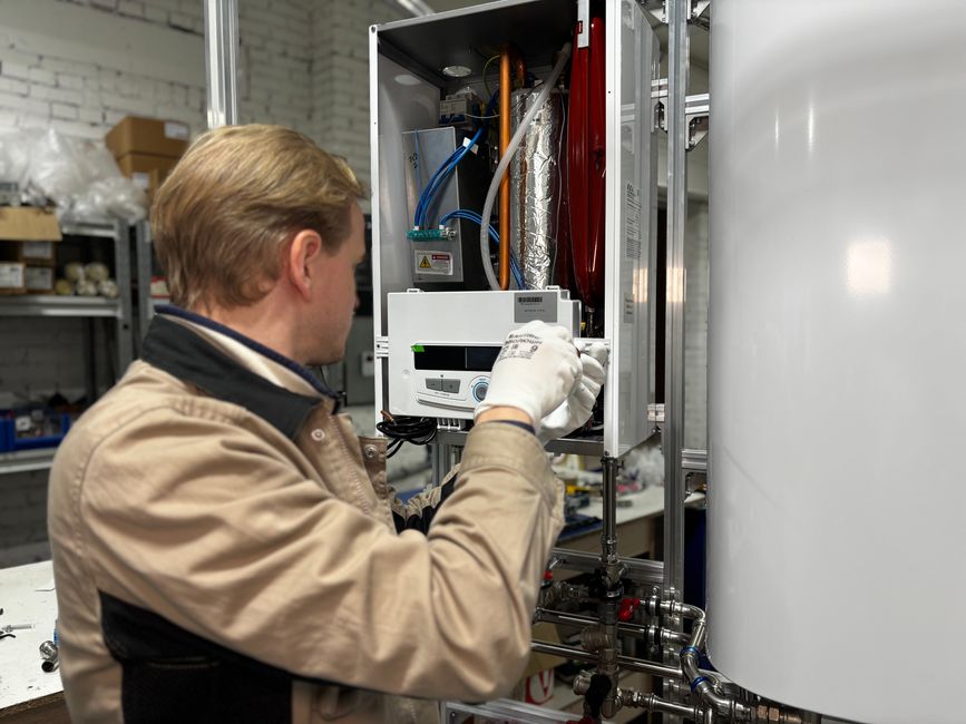 Plumber installing a wall-mounted water heater system